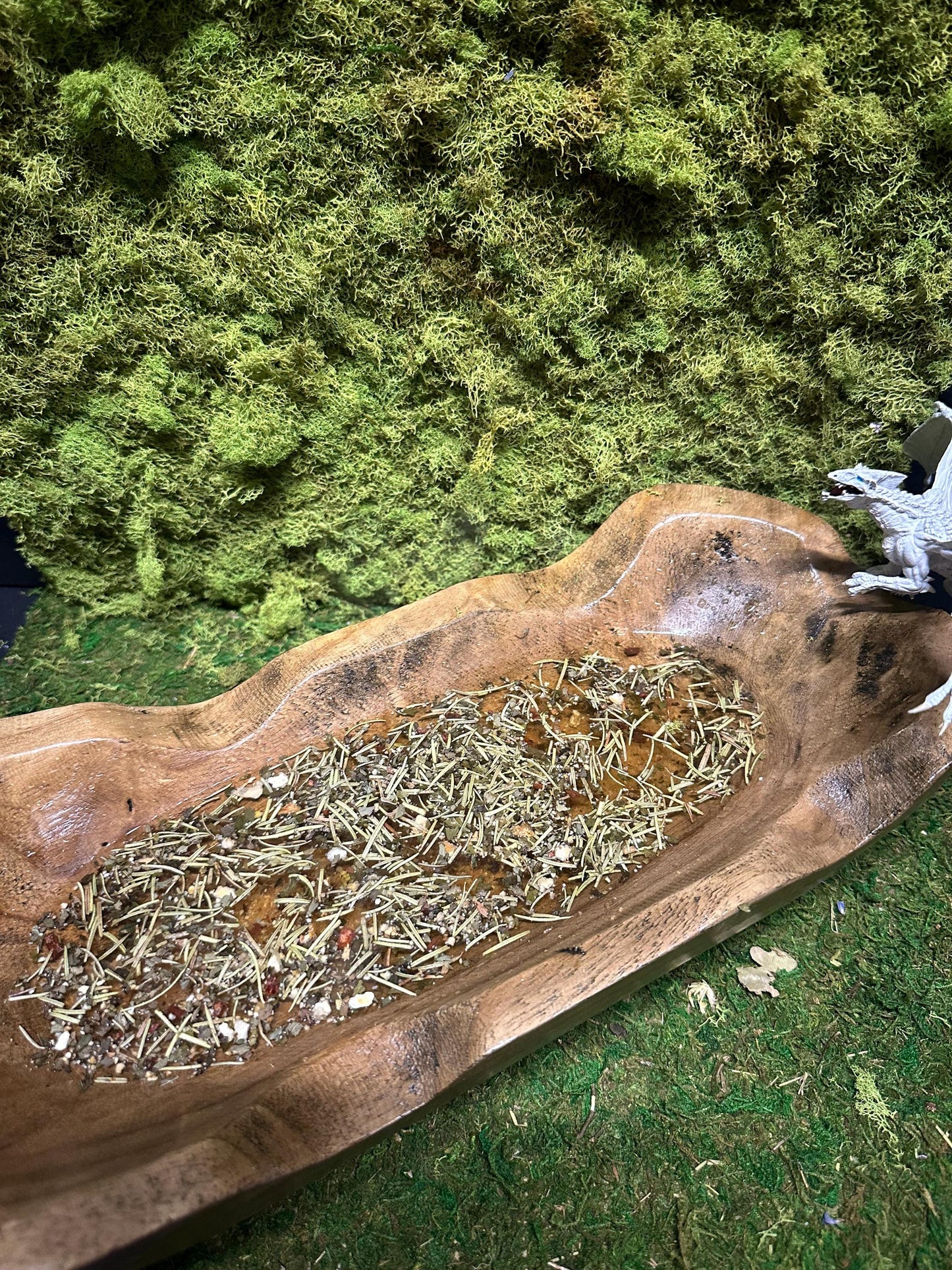 Dragon’s Breath Facial Steam elegantly presented in a rustic wooden oblong bowl, gently floating in water.